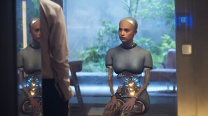 Die Roboterfrau Ava ist im Zentrum des Bildes zu sehen, sie befindet sich in einem Glaskasten.